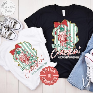 May include: Two t-shirts, one black and one white, with a Christmas-themed graphic. The design features a nutcracker, Christmas tree, and the text "Let's Get Crackin' Nutcracker Market Crew". A red "Option to Personalize" sticker is visible.