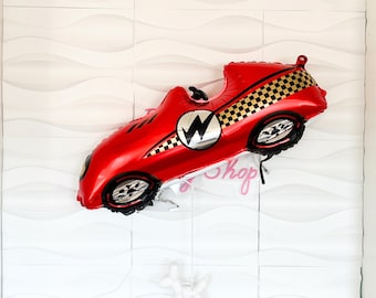 May include: Red race car shaped balloon with black and gold checkered pattern and a lightning bolt logo.