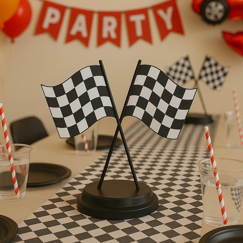May include: A black circular base supports two crossed black poles, each topped with a black and white checkered racing flag. The flags are positioned upright, creating a decorative centerpiece with a classic motor racing aesthetic for a table.