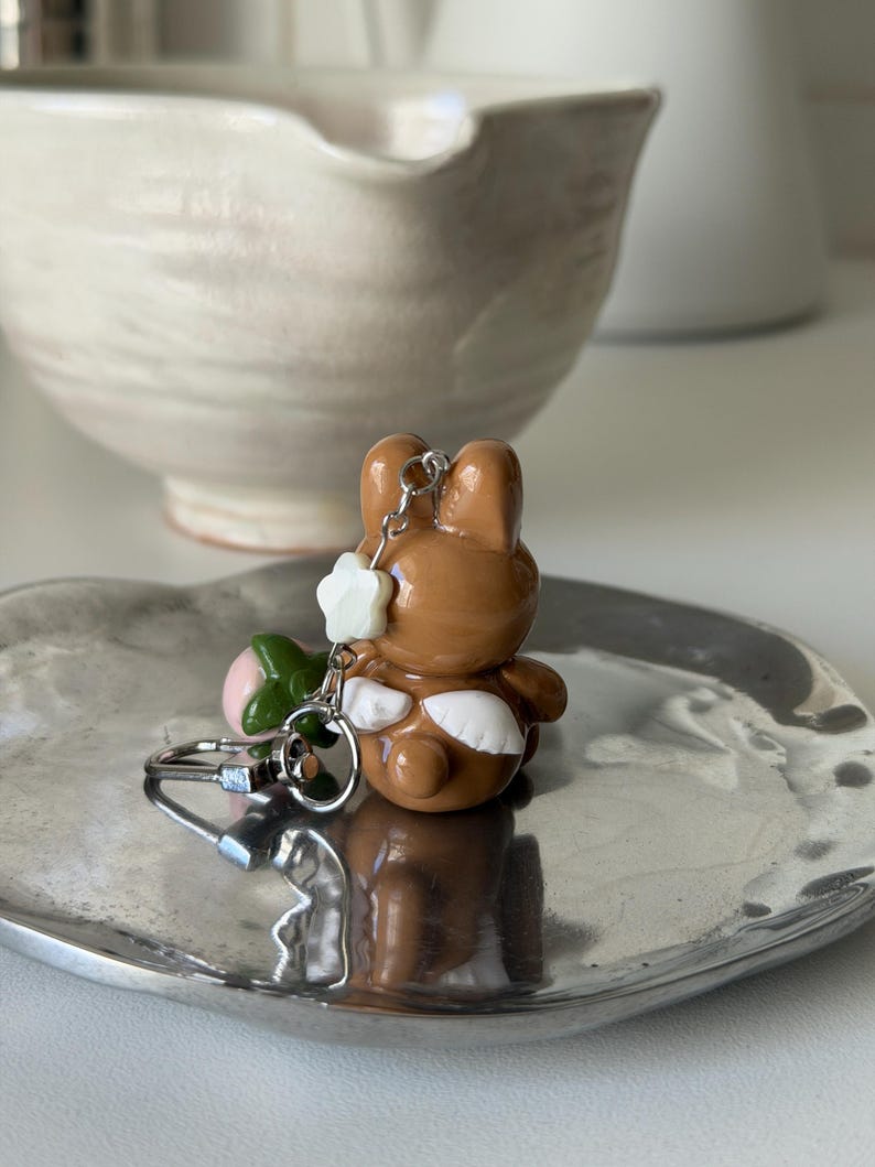May include: A set of three ceramic mugs with a speckled, matte finish. The mugs are in shades of cream, light gray, and dark gray. Each mug has a simple, minimalist design and a rounded handle.
