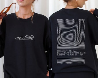 May include: Black sweatshirt with a white outline of a racing car on the front and the text "CHANGE YOUR CAR BECAUSE CHECO HAS BEEN SAYING THE CAR IS "RED" on the back.
