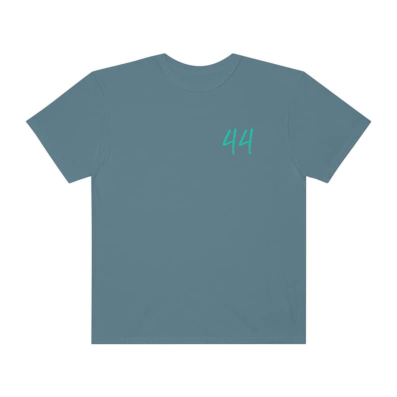 Peut inclure: Un t-shirt bleu sarcelle avec le num&eacute;ro 44 imprim&eacute; sur le devant en vert turquoise.
