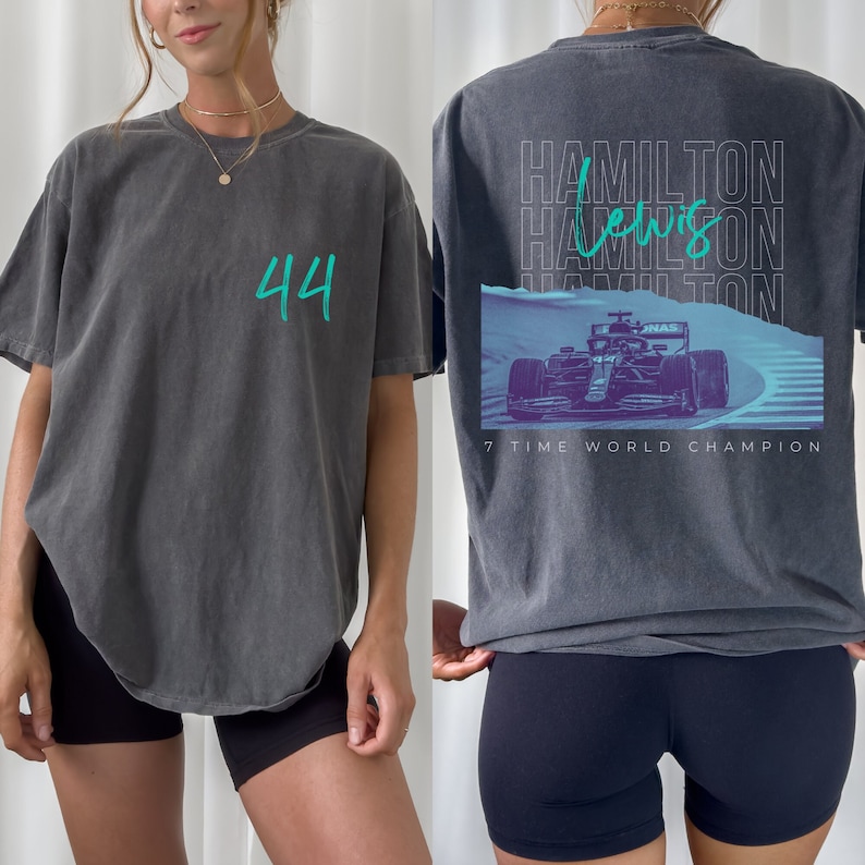 Peut inclure: Un t-shirt gris fonc&eacute; avec le num&eacute;ro 44 en vert turquoise sur le devant et un graphique d'une voiture de course avec le texte "Hamilton Lewis Hamilton 7 fois champion du monde" au dos.