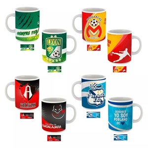 May include: Collection of white ceramic coffee mugs featuring various Mexican soccer team logos and designs. Each mug displays team colors, logos, and text, including "LEON", "MONARCAS", and "PUEBLA F.C."