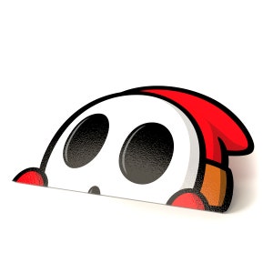 Puede incluir: Una pegatina troquelada que presenta un personaje de dibujos animados con una cara blanca, ojos negros grandes y una capucha roja. La cara del personaje está ligeramente inclinada. La pegatina tiene un acabado brillante.