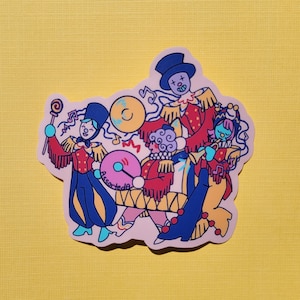 May include: A sticker featuring a group of four cartoon characters dressed as a band. The characters are playing musical instruments, including a drum, a trumpet, and a cymbal. The sticker is on a pink background with musical notes and a lollipop.