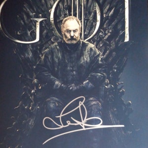 May include: A portrait of a man seated on the Iron Throne, with the letters "GOT" in the background. The man is wearing dark clothing and has a beard. The image is signed in white. The background is dark.