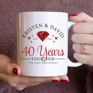 May include: White ceramic mug with a red ruby design and the text "Kristen & David Est. 1984 40 Years Together The Ruby Anniversary".