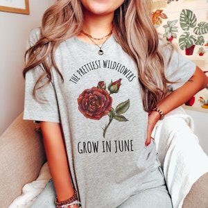 May include: Grey t-shirt with a red rose graphic and the text "The prettiest wildflowers grow in June."