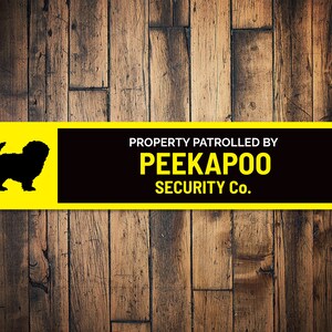 May include: Yellow and black sign with a silhouette of a dog and the text "PROPERTY PATROLLED BY PEEKAPOO SECURITY Co."