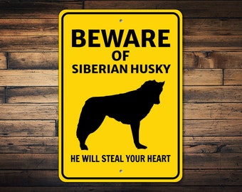 May include: Yellow warning sign with black text that reads "Beware of Siberian Husky. He will steal your heart." A black silhouette of a Siberian Husky is in the center of the sign.