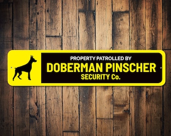 May include: Yellow and black sign with the text "PROPERTY PATROLLED BY DOBERMAN PINSCHER SECURITY CO." and a silhouette of a Doberman Pinscher.