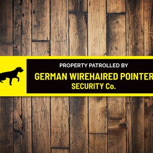 Pode incluir: Um sinal amarelo e preto com o texto "PROPERTY PATROLLED BY GERMAN WIREHAIRED POINTER SECURITY CO.". Uma silhueta preta de um Braco Alemão de Pelo Duro está no lado esquerdo do sinal.