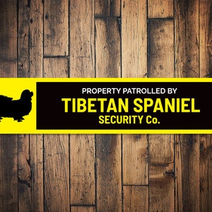 May include: Yellow and black sign with a silhouette of a Tibetan Spaniel and the text "PROPERTY PATROLLED BY TIBETAN SPANIEL SECURITY Co."