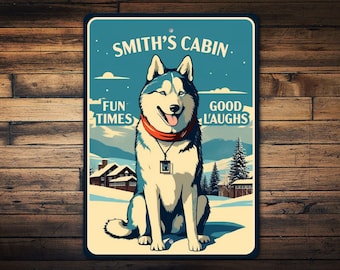 Könnte beinhalten: Ein blauer und weißer Husky-Hund sitzt vor einer Hütte in einer verschneiten Landschaft. Das Schild über dem Hund lautet "Smith's Cabin" mit dem Text "Fun Times" und "Good Laughs" auf beiden Seiten des Hundes.