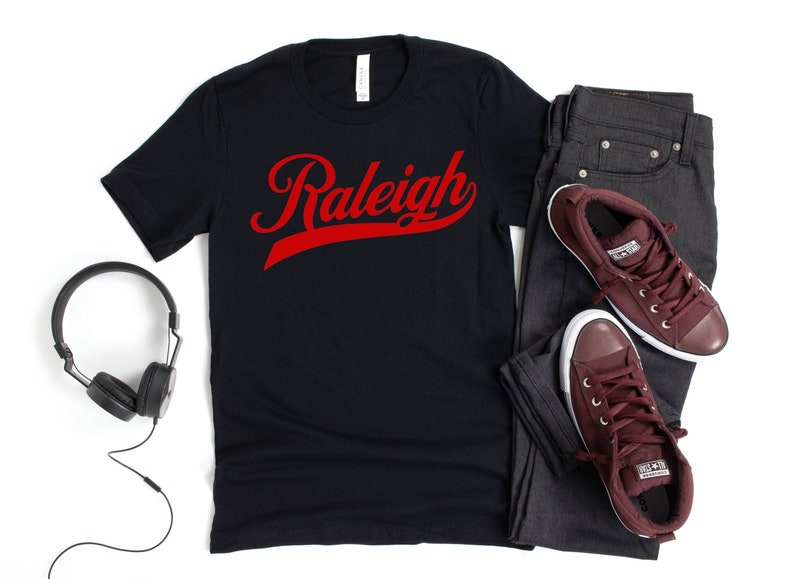 May include: Black t-shirt with a red "Raleigh" graphic in a vintage baseball font.