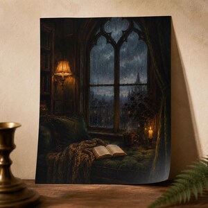 May include: A wall art print depicting a cozy window nook on a rainy night. An open book rests on a green tufted cushion beside a steaming mug and a lit candle. A warm wall lamp illuminates a bookshelf, while a gothic window overlooks a dark city.