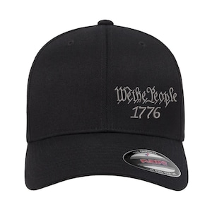 May include: Black baseball cap with a white embroidered inscription that reads "We the People 1776".