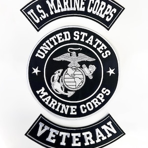 May include: Three black and white patches. The top patch reads "U.S. MARINE CORPS" in white block letters. The center patch is circular, with the words "UNITED STATES MARINE CORPS" and a central emblem. The bottom patch reads "VETERAN".