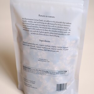 Pu&ograve; includere: Un sacchetto bianco e richiudibile di granola Illumination Living Foods. La confezione presenta testo, tra cui "Return to nature" e un elenco di ingredienti: avena biologica, noci, uvetta, olio d'oliva, sciroppo d'acero, vaniglia, cannella, noce moscata e sale rosa.