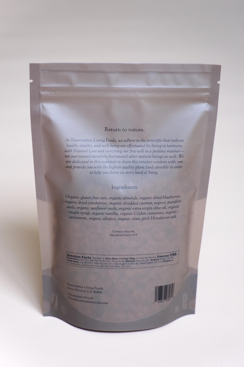 Puede incluir: Una bolsa resellable de color claro con ingredientes org&aacute;nicos, incluyendo avena, almendras y ar&aacute;ndanos. La bolsa presenta texto sobre los ingredientes y la informaci&oacute;n nutricional del producto.