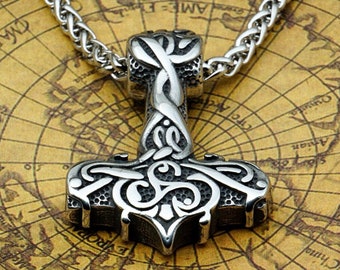 May include: A silver Mjolnir pendant with intricate knotwork designs, hanging from a silver chain. The pendant is on a brown map background.