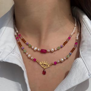 Boho Colorful Evil Eye Necklace with Gold Accents, Freshwater Pearls & Red Crystal Charm – Handmade Beaded Protection Jewelry
