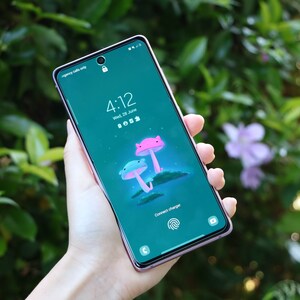 Può includere: Uno smartphone rosa e blu con uno schermo verde che mostra un'icona di blocco, l'ora 4:12, la data mer 28 giugno e il testo "Connect charger". Lo schermo presenta anche un'immagine di cartoni animati di due funghi con luci brillanti.