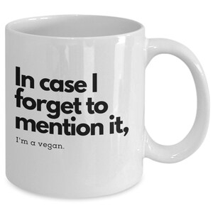 Puede incluir: Taza de café de cerámica blanca con texto negro que dice "En caso de que olvide mencionarlo, soy vegano."