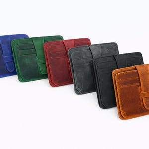 May include: A collection of leather card wallets in various colors, including blue, green, red, gray, black, and brown. Each wallet features multiple card slots and a secure flap closure. The wallets are arranged diagonally on a white background.