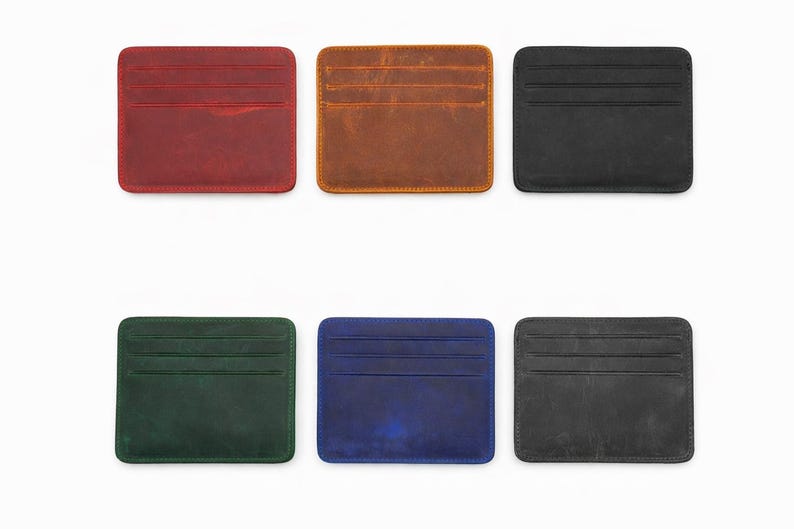 May include: Six leather cardholders in various colors: red, brown, black, green, blue, and gray. Each cardholder has a rectangular shape with rounded corners and multiple card slots. The cardholders are displayed on a white background.