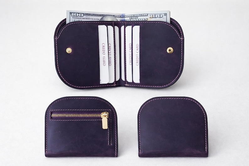 K&ouml;nnte beinhalten: Ein Set aus drei dunkelvioletten Ledergeldb&ouml;rsen. Eine Geldb&ouml;rse ist ge&ouml;ffnet und zeigt Kreditkarten und einen Stapel 100-Dollar-Scheine. Die anderen beiden Geldb&ouml;rsen sind geschlossen, eine mit Rei&szlig;verschluss und goldfarbener Hardware.