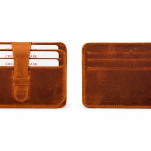 May include: Two brown leather cardholders are displayed against a white background. One is open, revealing three white cards with the word "CRED CARD" visible. The other shows the back with multiple card slots.