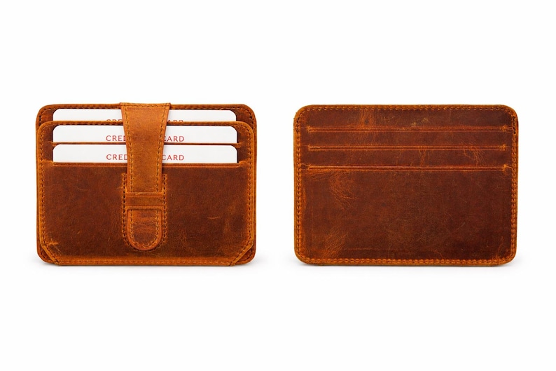 May include: Two brown leather cardholders are displayed against a white background. One is open, revealing three white cards with the word "CRED CARD" visible. The other shows the back with multiple card slots.