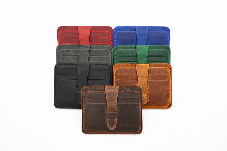 May include: A collection of leather card wallets in various colors, including red, blue, green, black, and brown. Each wallet features a secure flap closure and multiple card slots. The wallets are arranged on a white background.