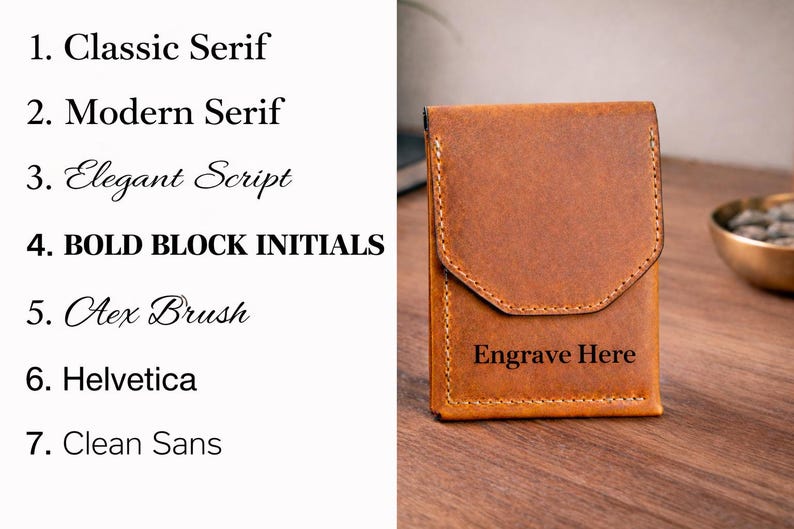 May include: A brown leather wallet with a flap closure, featuring the text "Engrave Here" on the front. The image also displays a list of font styles, including "Classic Serif" and "Bold Block Initials".