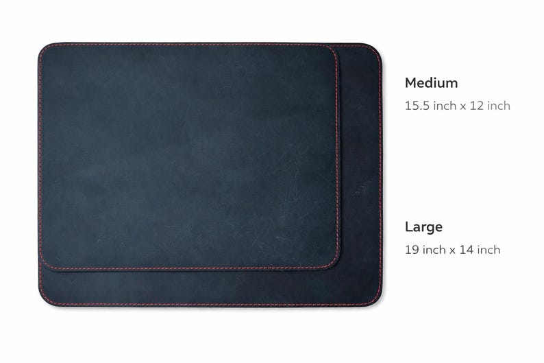 May include: Two dark blue rectangular desk mats with red stitching. The medium mat measures 15.5 inches by 12 inches, and the large mat is 19 inches by 14 inches. The mats are displayed on a white background.
