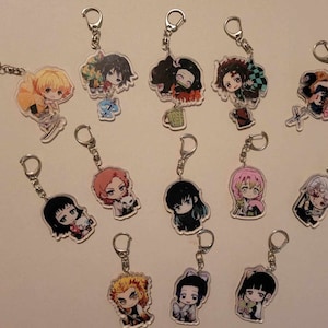 May include: A collection of anime-style character keychains. Each keychain features a different character with vibrant colors and detailed designs. The keychains are attached to silver-colored metal key rings.