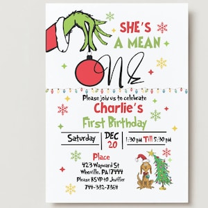 May include: A white invitation card with a Grinch theme. The card features the text "She's a Mean One" and "Charlie's First Birthday." The Grinch's green hand holds a red ornament. Additional graphics include snowflakes and a dog with a Santa hat.
