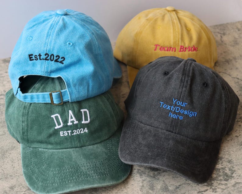 Pode incluir: Tr&ecirc;s bon&eacute;s de beisebol bordados. Um &eacute; azul com o texto "Est. 2022", outro &eacute; verde com o texto "DAD EST. 2024" e o &uacute;ltimo &eacute; amarelo com o texto "Team Bride".