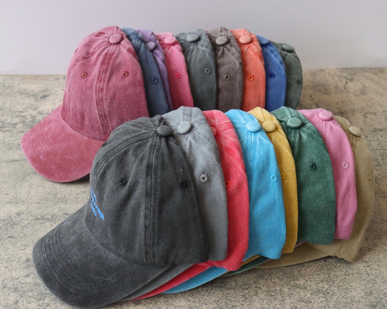 Pode incluir: Uma pilha de 12 bon&eacute;s de beisebol de diferentes cores. Os bon&eacute;s s&atilde;o feitos de um tecido de sarja macio e desbotado. Os bon&eacute;s s&atilde;o todos em v&aacute;rios tons de azul, verde, vermelho, rosa e amarelo.
