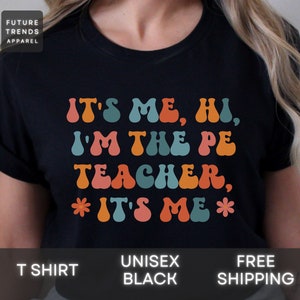 May include: Black t-shirt with a retro-style graphic that reads "It's Me, Hi, I'm the PE Teacher, *It's Me*"