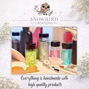 May include: Image features several clear jars filled with glitter in various colors, including green, silver, pink, and blue. The jars have black lids. The text "Everything is handmade with high quality products" is at the bottom of the image.