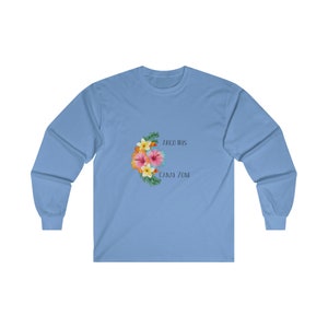 May include: A light blue long-sleeved t-shirt with a floral design and the text "Arco Iris Canal Zone" printed on the front.