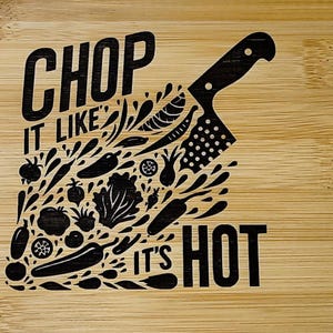 May include: A wooden cutting board with a black design that says "Chop it like it's hot" with a knife and vegetables.