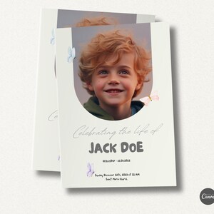 May include: A light beige memorial card with a photo of a young boy smiling. The card has a white oval around the photo with butterflies in the corners. The text "Celebrating the life of JACK DOE" is in a gray font. The dates "08.11.1917 - 31.01.2023" are below the name. The text "Sunday, December 12th, 2023 at 11 AM" and "Sant Maria Church" are at the bottom of the card.