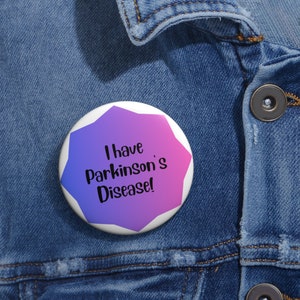 Puede incluir: Un botón morado y azul con forma de estrella y el texto "¡Tengo la enfermedad de Parkinson!" en una chaqueta vaquera.
