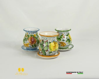 Peut inclure: Trois vases en céramique peints à la main avec des soucoupes assorties. Chaque vase présente un motif unique de fruits et de feuillage aux couleurs vives. Les vases sont posés sur un fond blanc, mettant en valeur le savoir-faire italien.