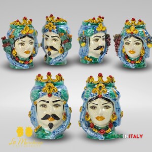 May include: Set of six ceramic decorative vases featuring colorful, hand-painted faces with intricate details. The vases are shaped like heads with crowns and feature a variety of floral and fruit motifs.