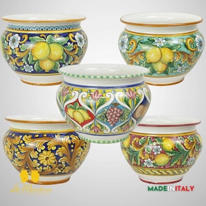 May include: Five ceramic flower pots with different colorful floral and fruit designs. The pots are all round and have a wide opening. The designs include lemons, grapes, and flowers.